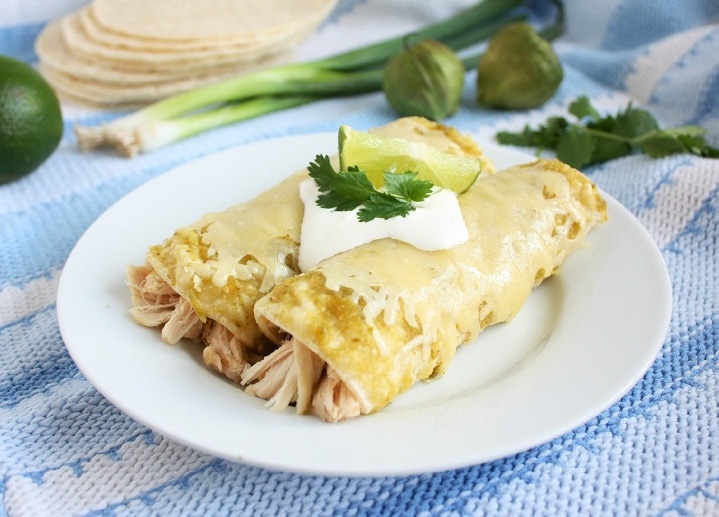 chicken enchiladas with green sauce on a white plate