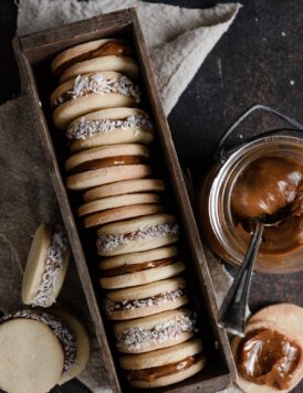 Alfajores cookies in a long wooden box.