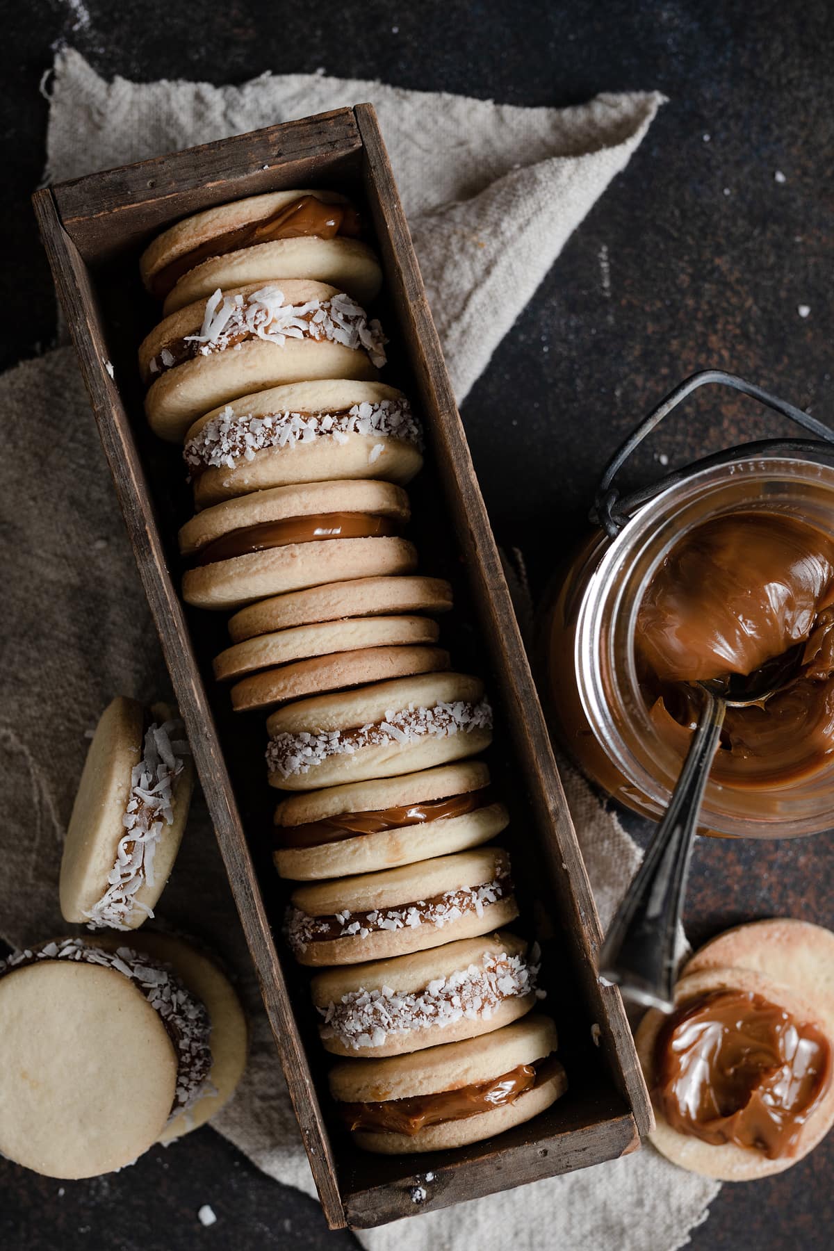 Alfajores cookies in a long wooden box.