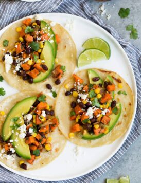 Three sweet potato and black bean tacos on white plate.