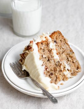 Single slice of homemade hummingbird cake on a white dessert plate.