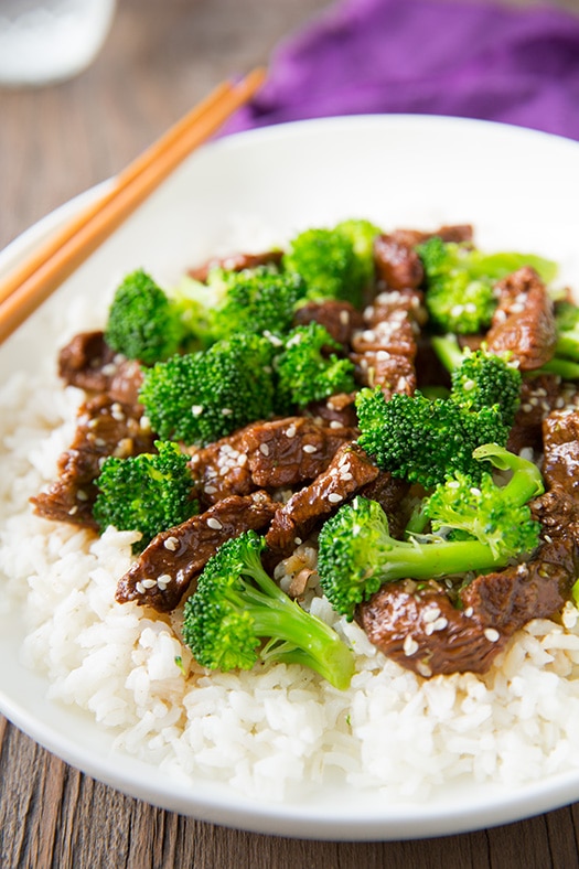 Slow Cooker Beef and Broccoli in white bowl with rice and chopsticks