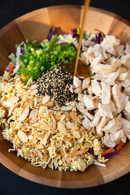 pouring dressing onto Asian Ramen Salad