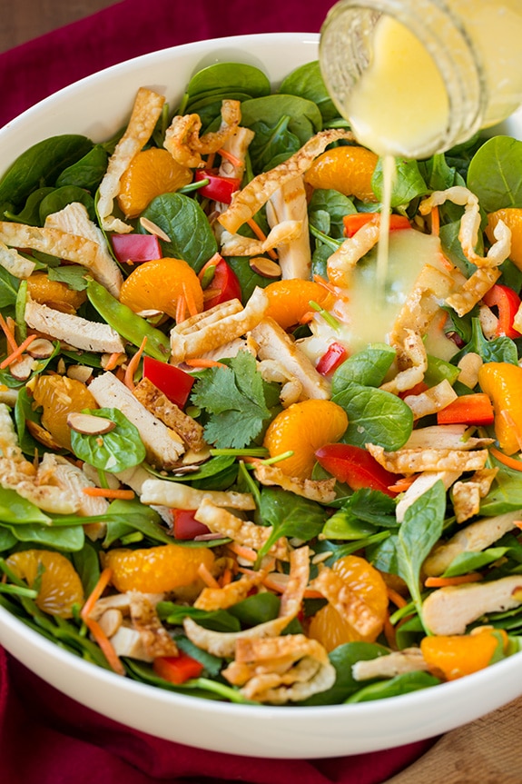 pouring lemon ginger dressing onto mandarin orange salad