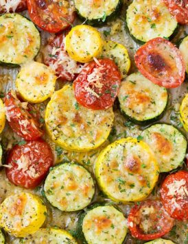 A close up of roasted zucchini and other veg on a roasting pan