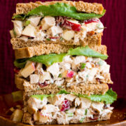 Chicken salad with apples shown in whole wheat bread slices as stacked sandwiches.