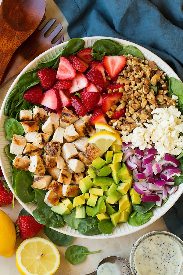 strawberry spinach salad ingredients in a serving bowl before tossing.