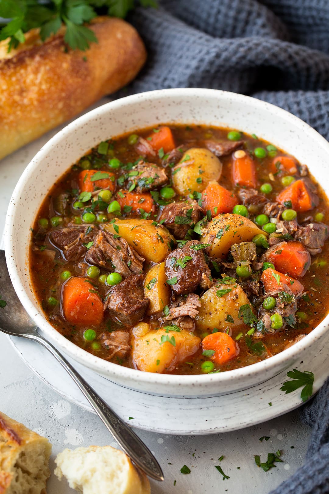 Slow Cooker Beef Stew in a white bowl with bread on the side