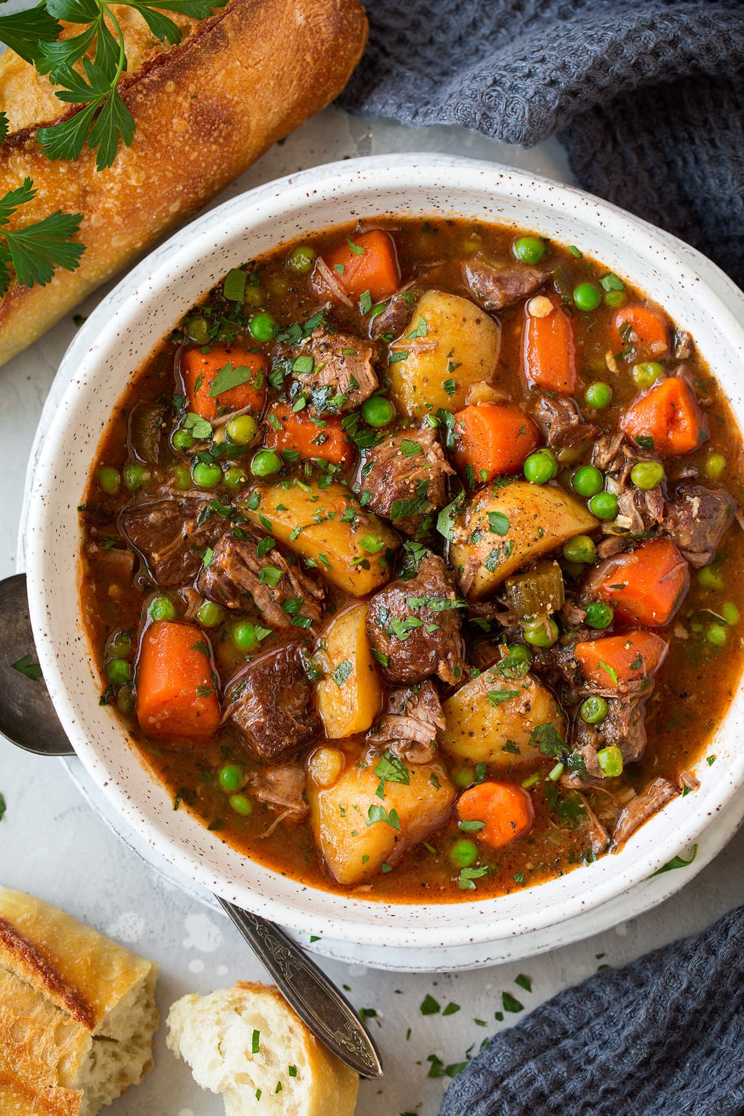 slow cooker Beef Stew shown in a single serving in a white bowl with bread as a side.