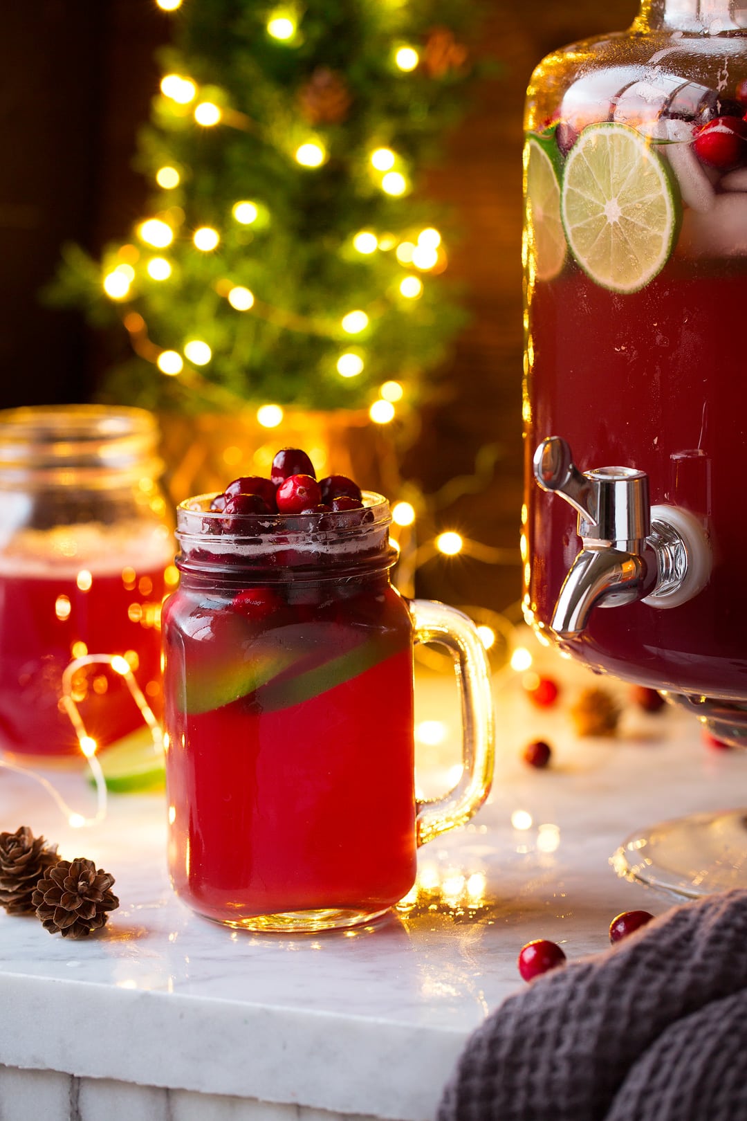 Punch recipe. Shown here in a mug with a dispenser of punch in the background.