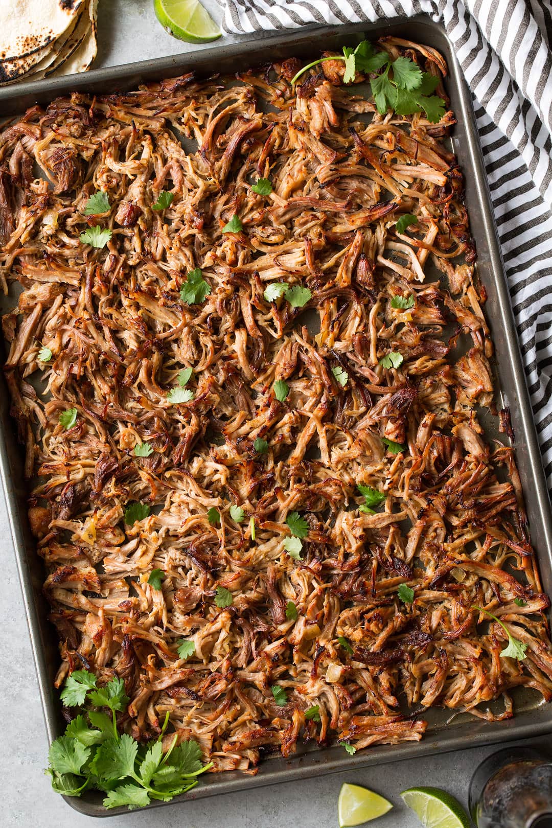 Carnitas shown here after broiling on a dark baking sheet garnished with cilantro