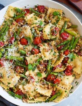 ravioli with tomatoes asparagus walnuts parmesan garlic herbs in serving bowl