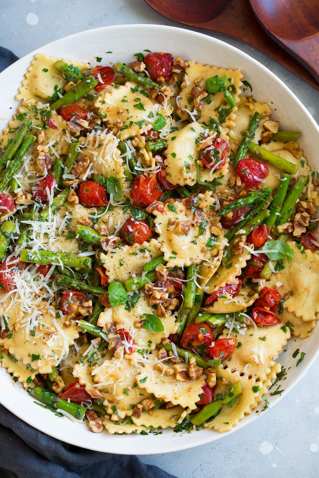 ravioli with tomatoes asparagus walnuts parmesan garlic herbs in serving bowl