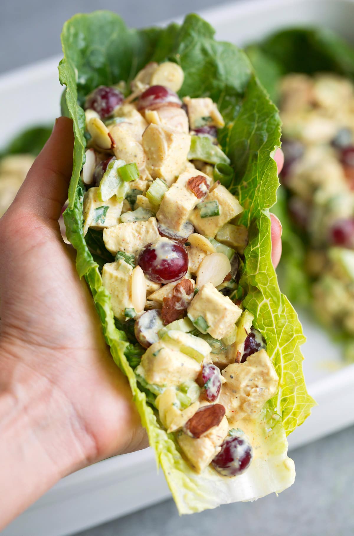 hand holding Curry Chicken Salad in a lettuce leaf