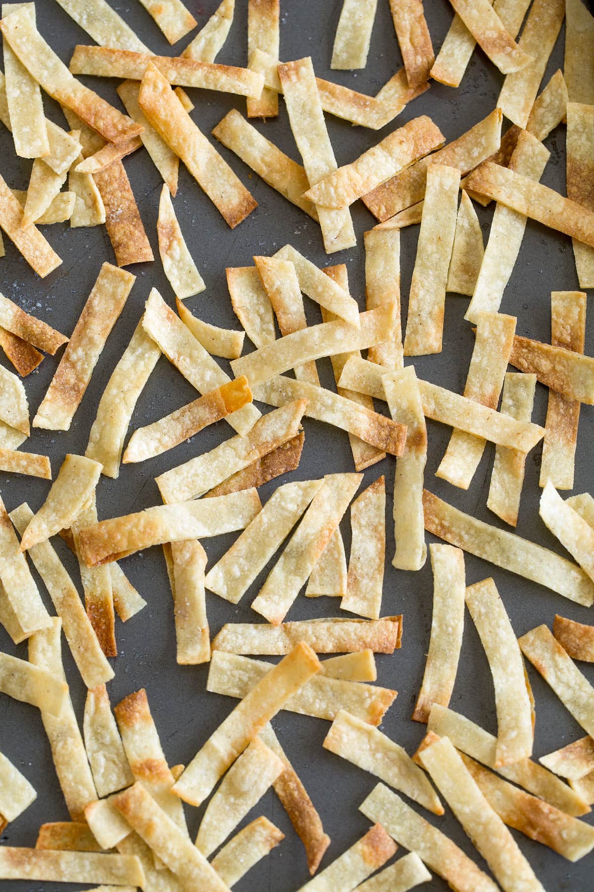 showing here finished baked tortilla strips on sheet pan for black bean tortilla soup