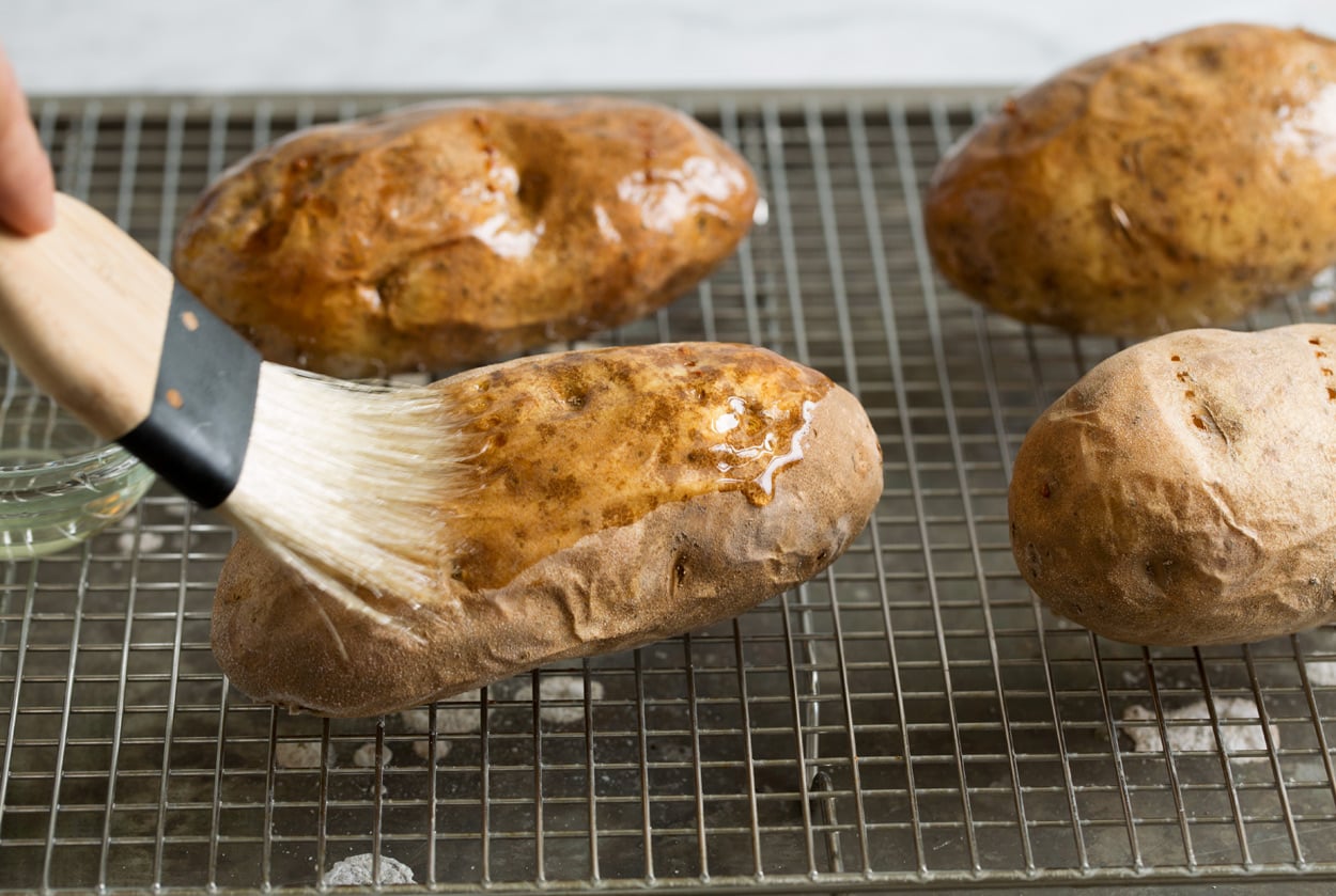 Baked Potatoes shown here brushing with vegetable oil