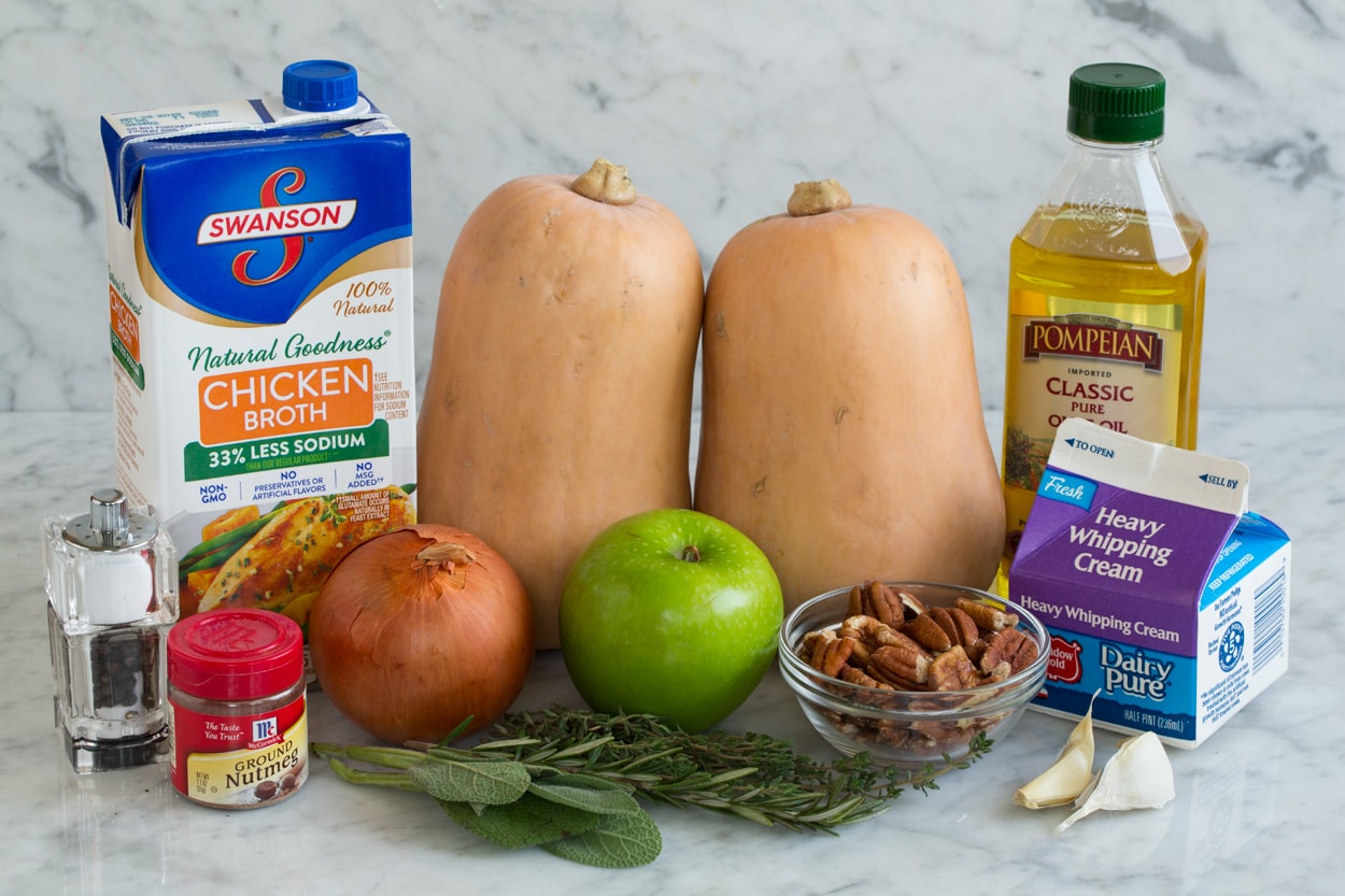 Ingredients for Butternut Squash Soup shown here squash chicken broth apples olive oil onion garlic cream nutmeg herbs pecans