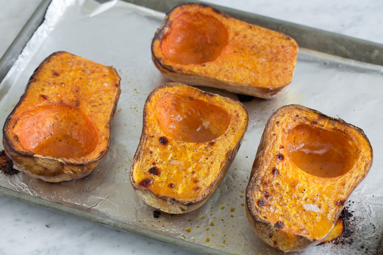 Roasted squash halves shown here on baking sheet for butternut squash soup