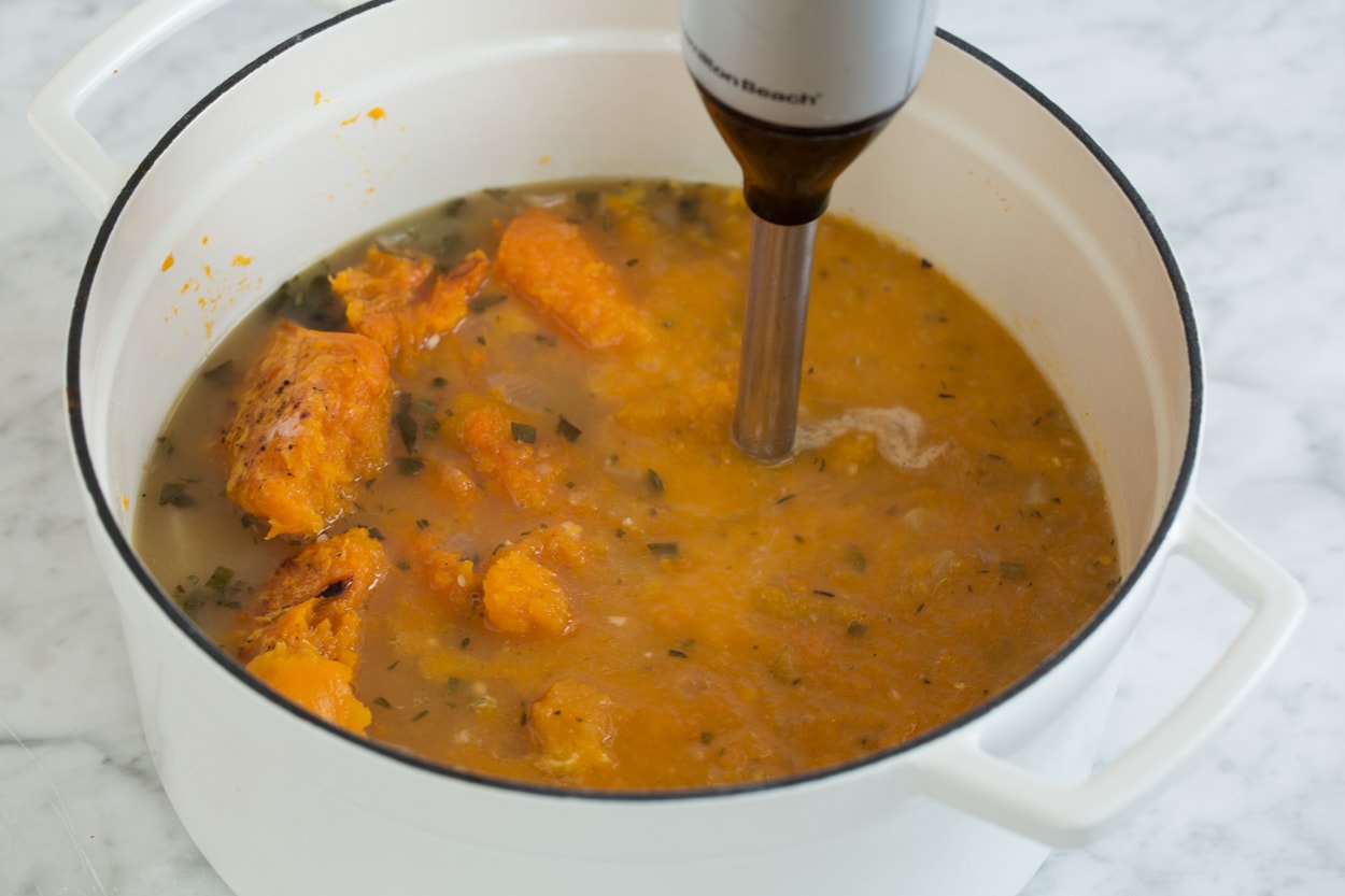 Shown here blending roasted squash into soup mixture in pot with an immersion blender for butternut squash soup