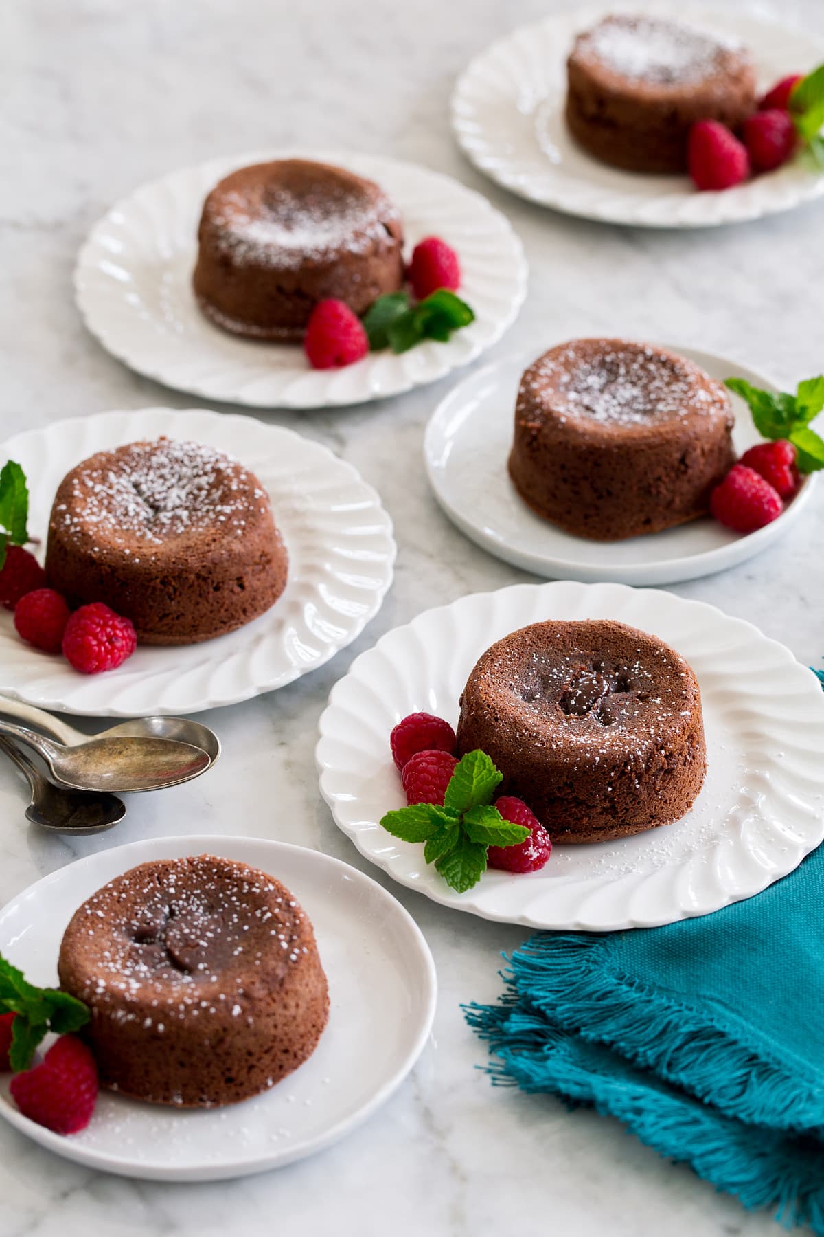 Six molten lava cakes on small dessert plates.