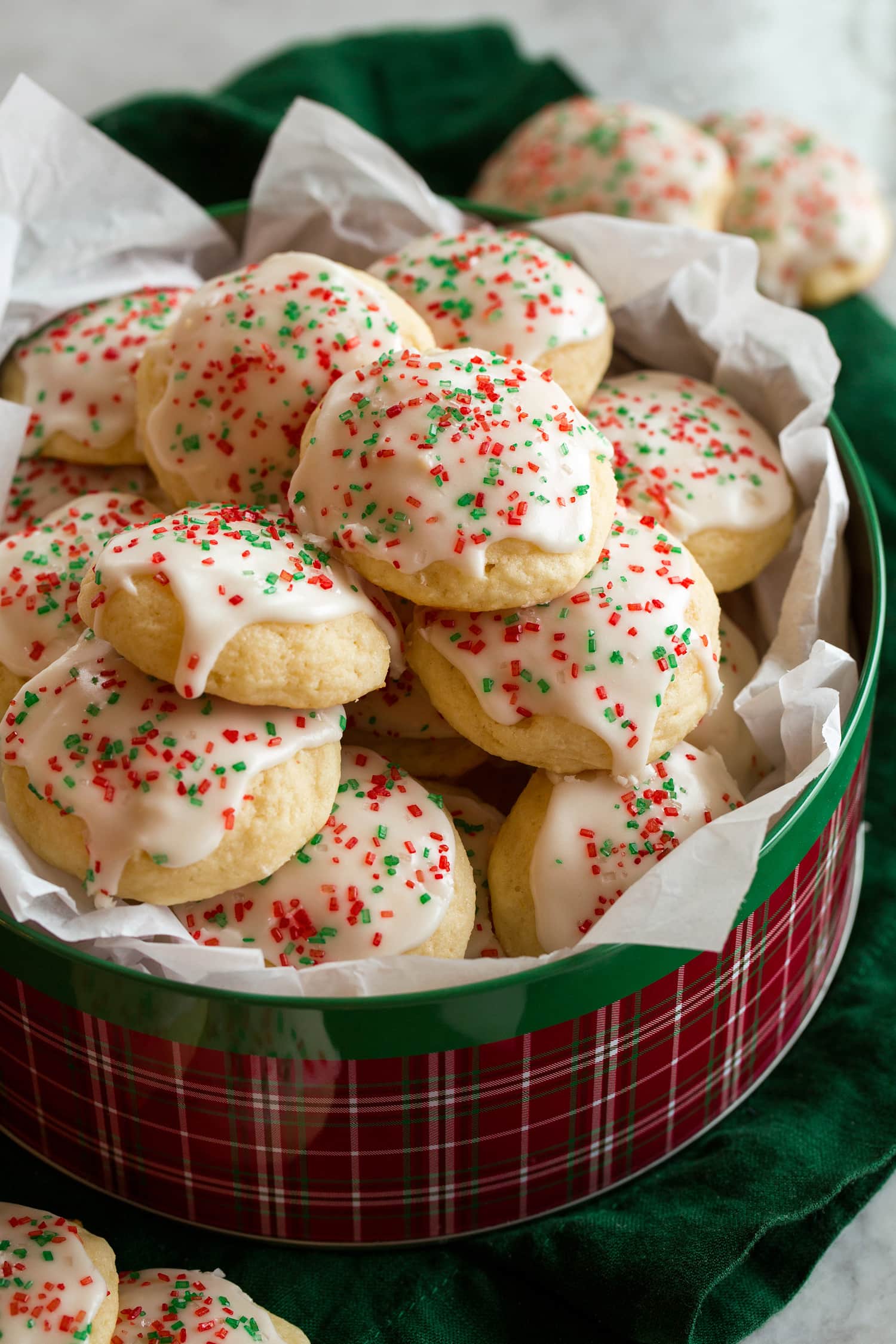 Ricotta cookies stacked in a Christmas tin.