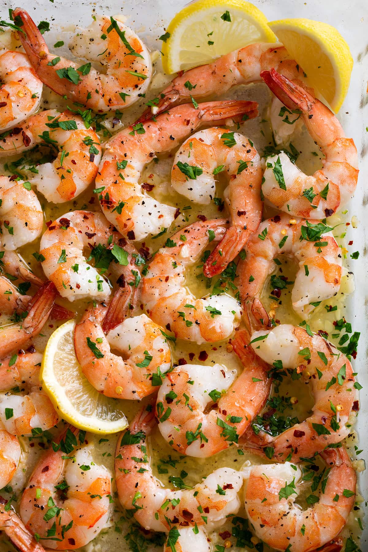 Close up image of baked shrimp in baking dish.