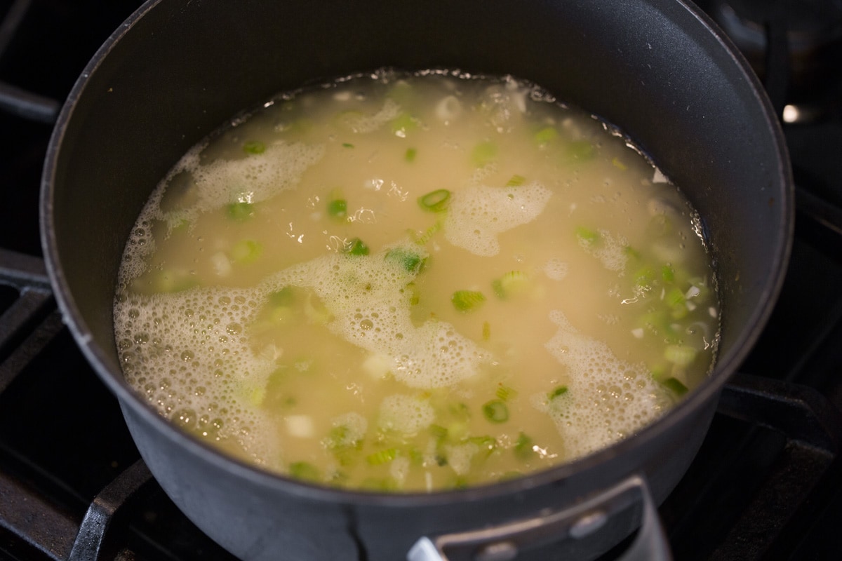 Boiling water in saucepan with rice and flavorings.