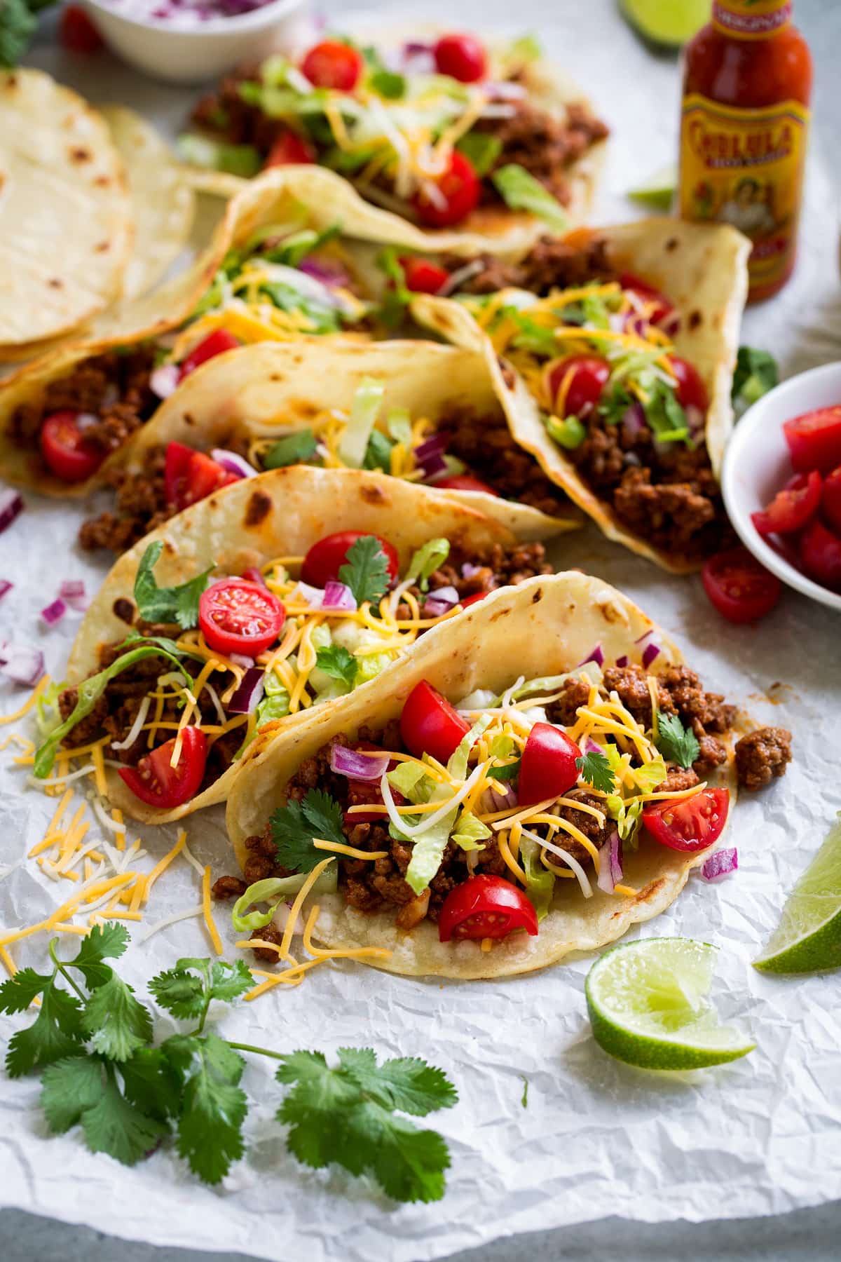 Meat tacos served with cheese, lettuce, tomatoes and Mexican hot sauce. 