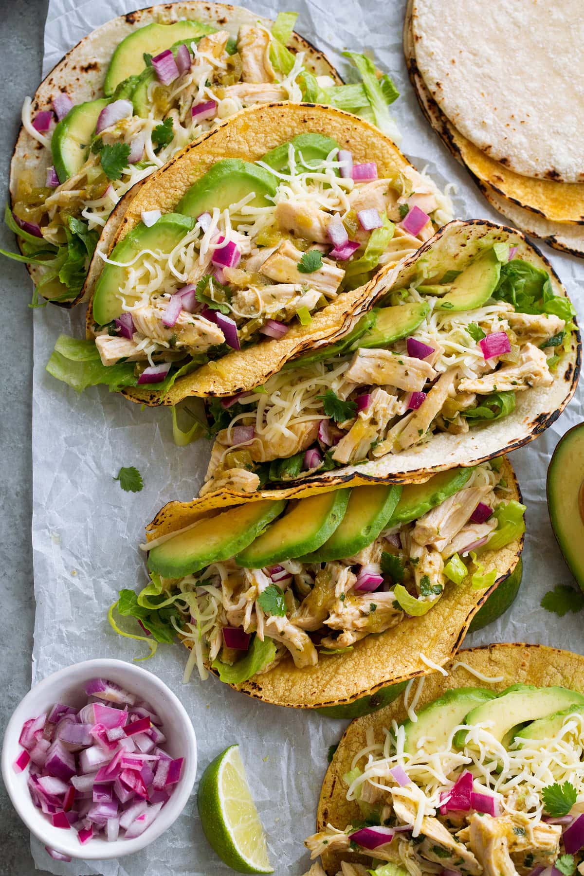 Row of salsa verde chicken in tacos. 