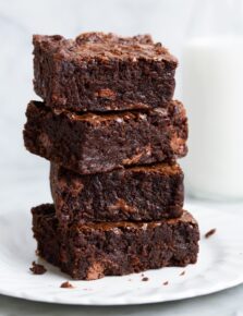 Stack of brownies on a white dessert plate.