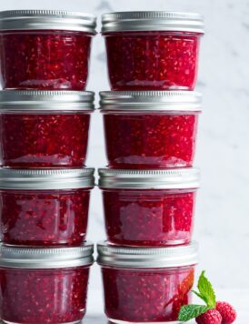 Raspberry jam in small glass mason jars.