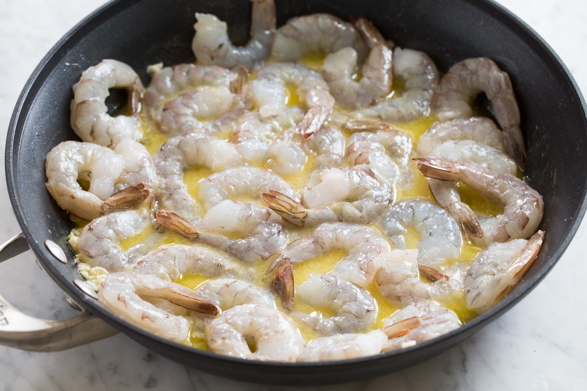 Sauteing shrimp in scampi sauce.