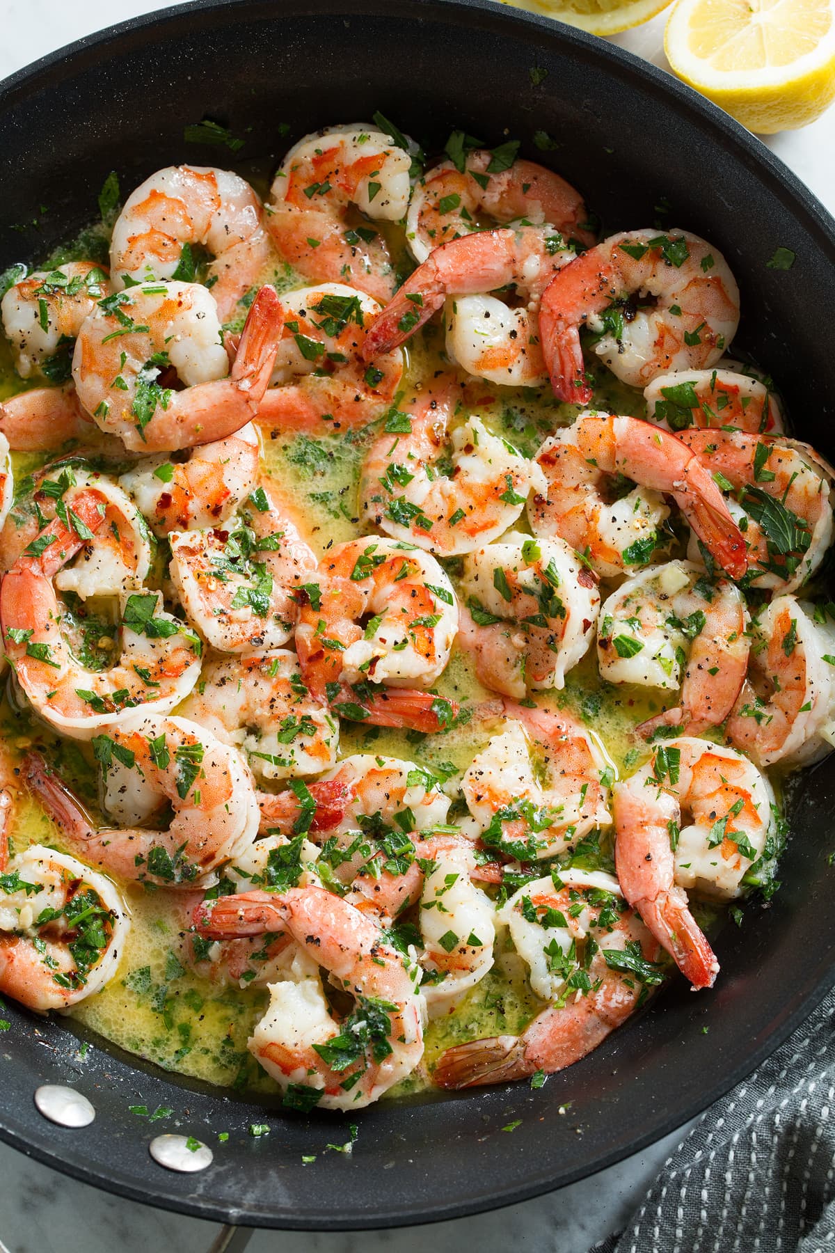 Overhead close up image of shrimp scampi in a skillet after cooking.