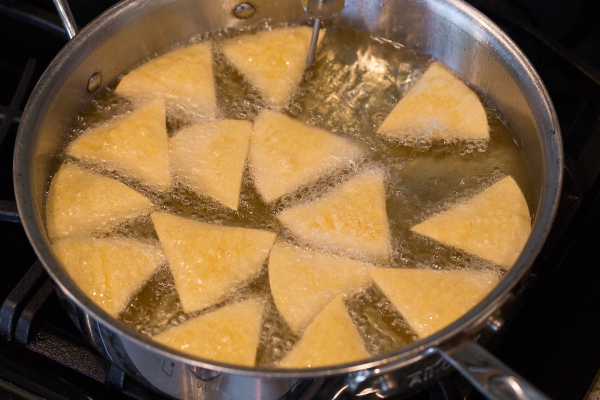 Frying tortilla chips in vegetable oil.