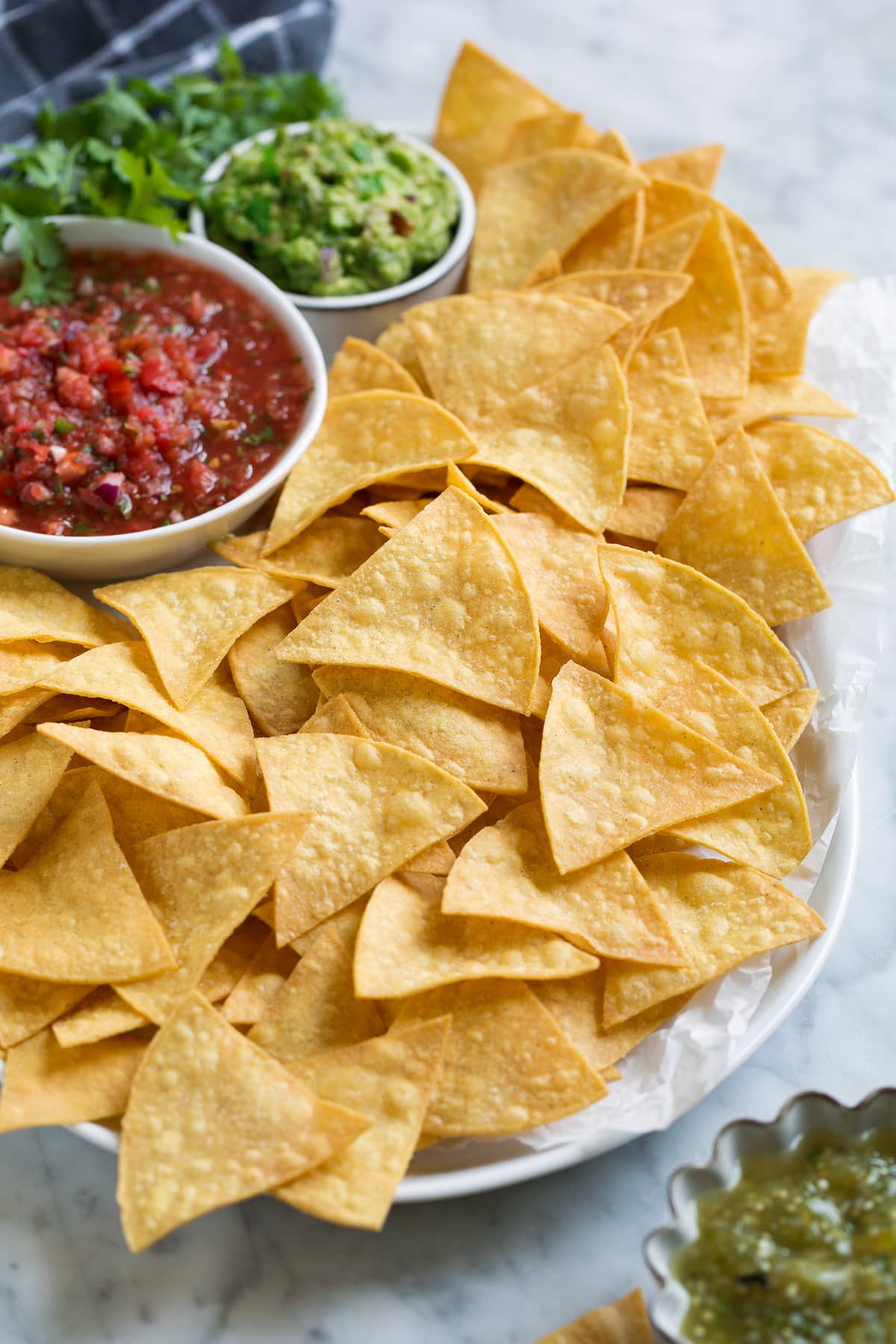 Serving dish full of tortilla chips and dips.