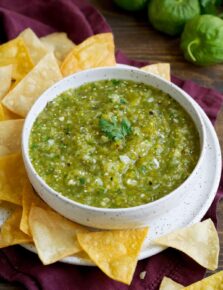 Salsa Verde in a bowl with a side of tortilla chips.