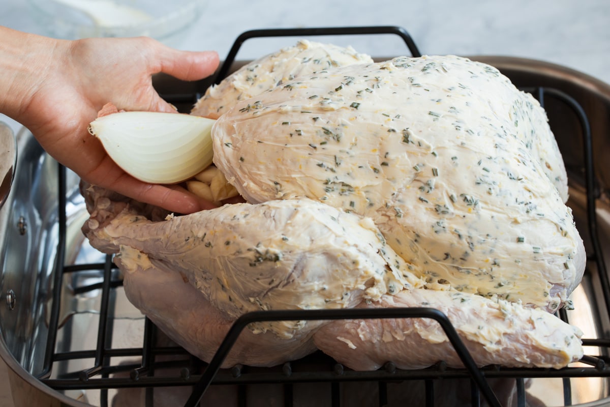 Stuffing turkey with quartered onion and smashed garlic.