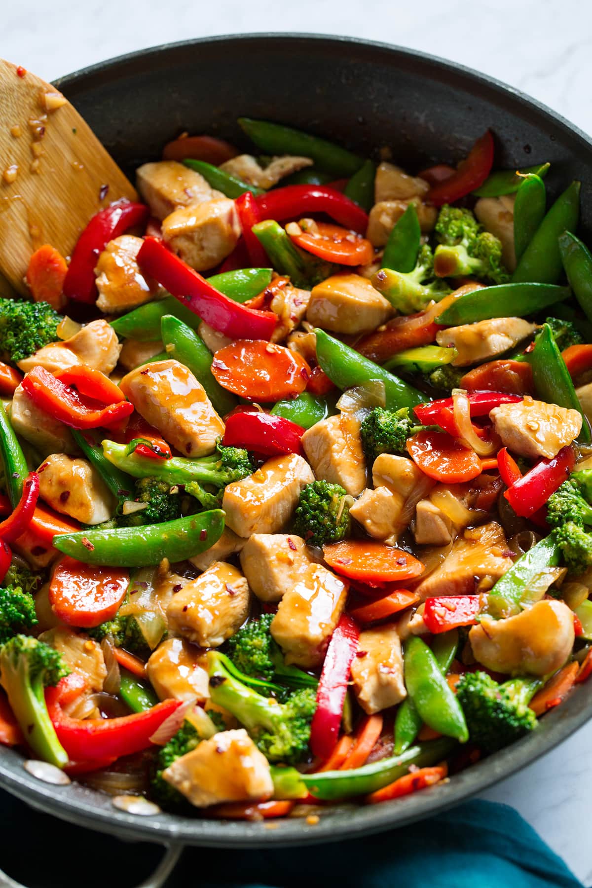 Close up image of chicken and vegetable stir fry in a skillet.