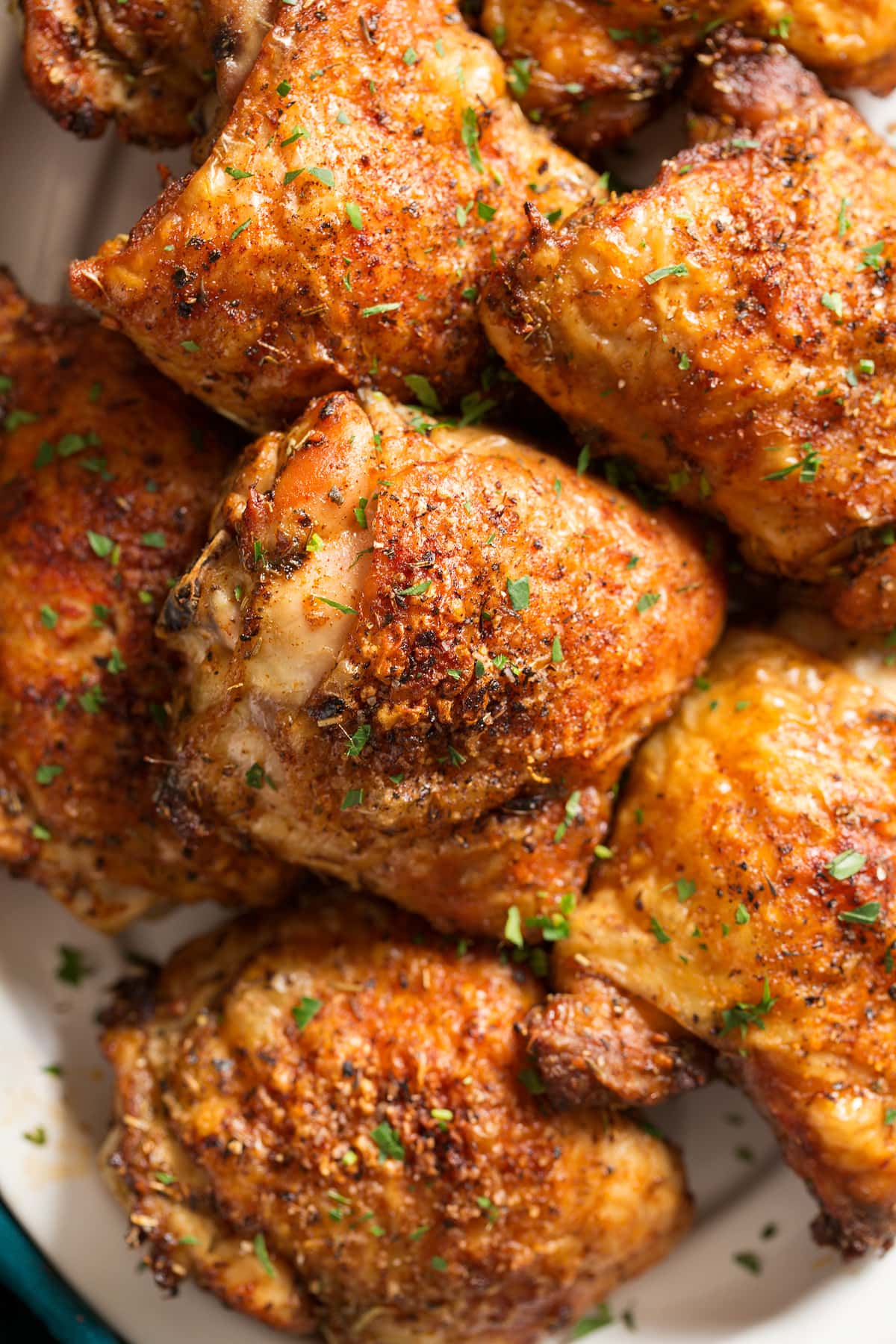 Baked chicken thighs stacked together on a platter.