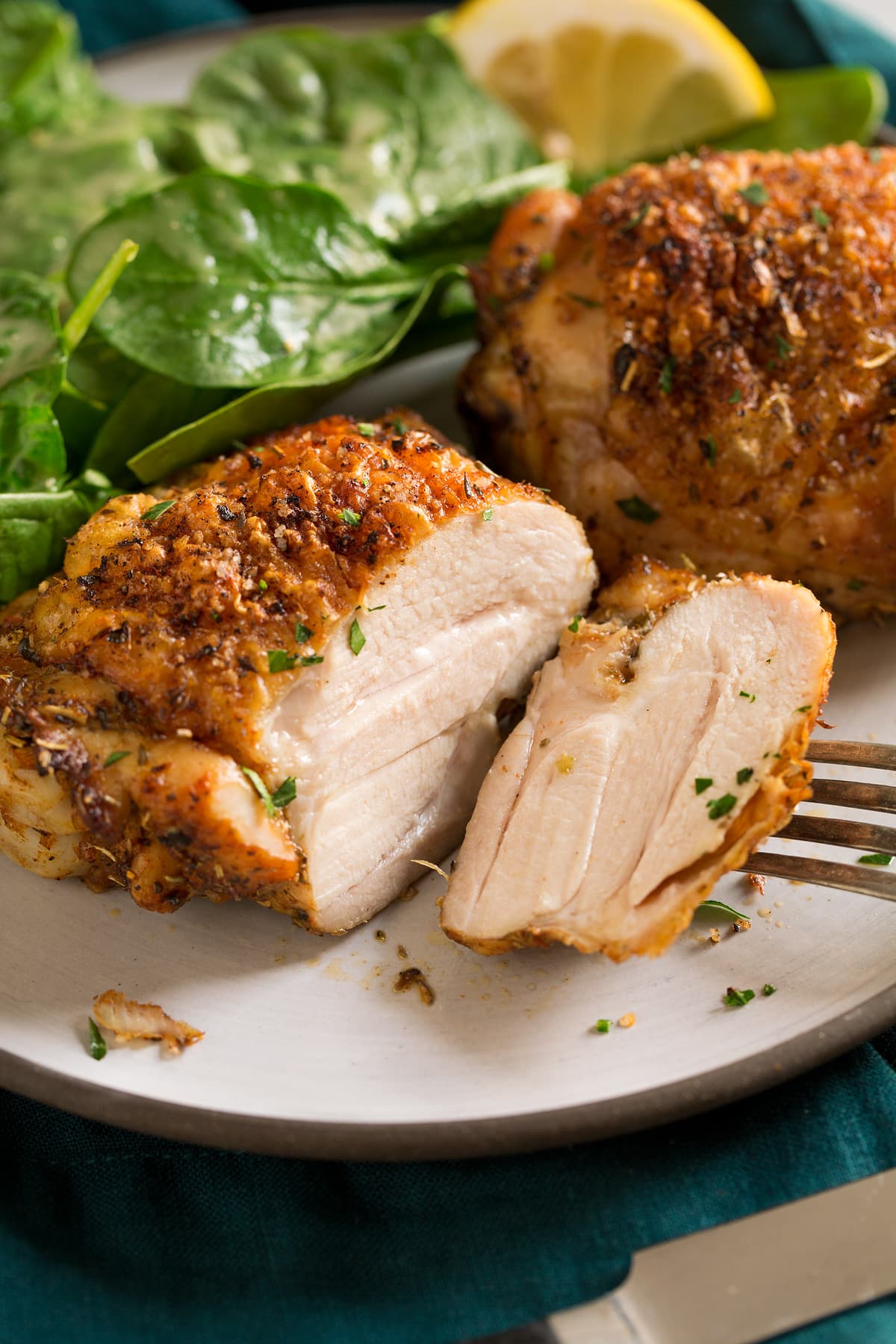 Baked chicken thigh sliced into on a serving plate.