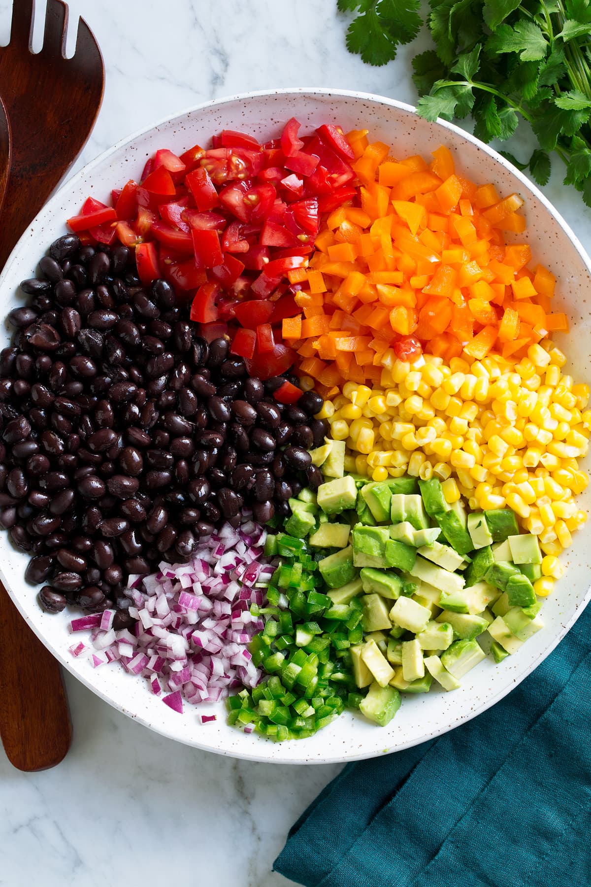 Black bean and corn salad ingredients in a mixing bowl before tossing together.