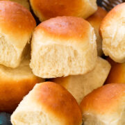 Close up photo of homemade dinner roll showing soft and fluffy texture and golden brown tops.