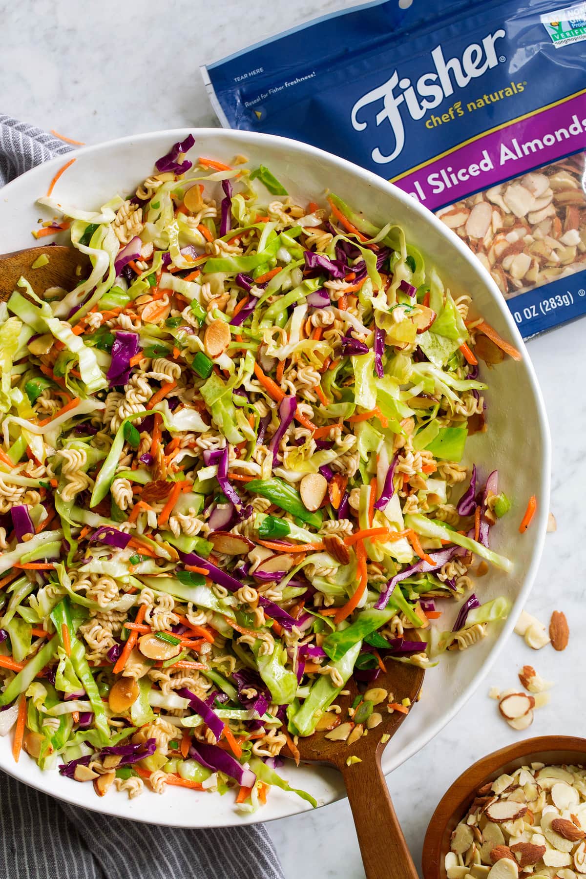 Overhead image of ramen noodle salad tossed together in a large white bowl.