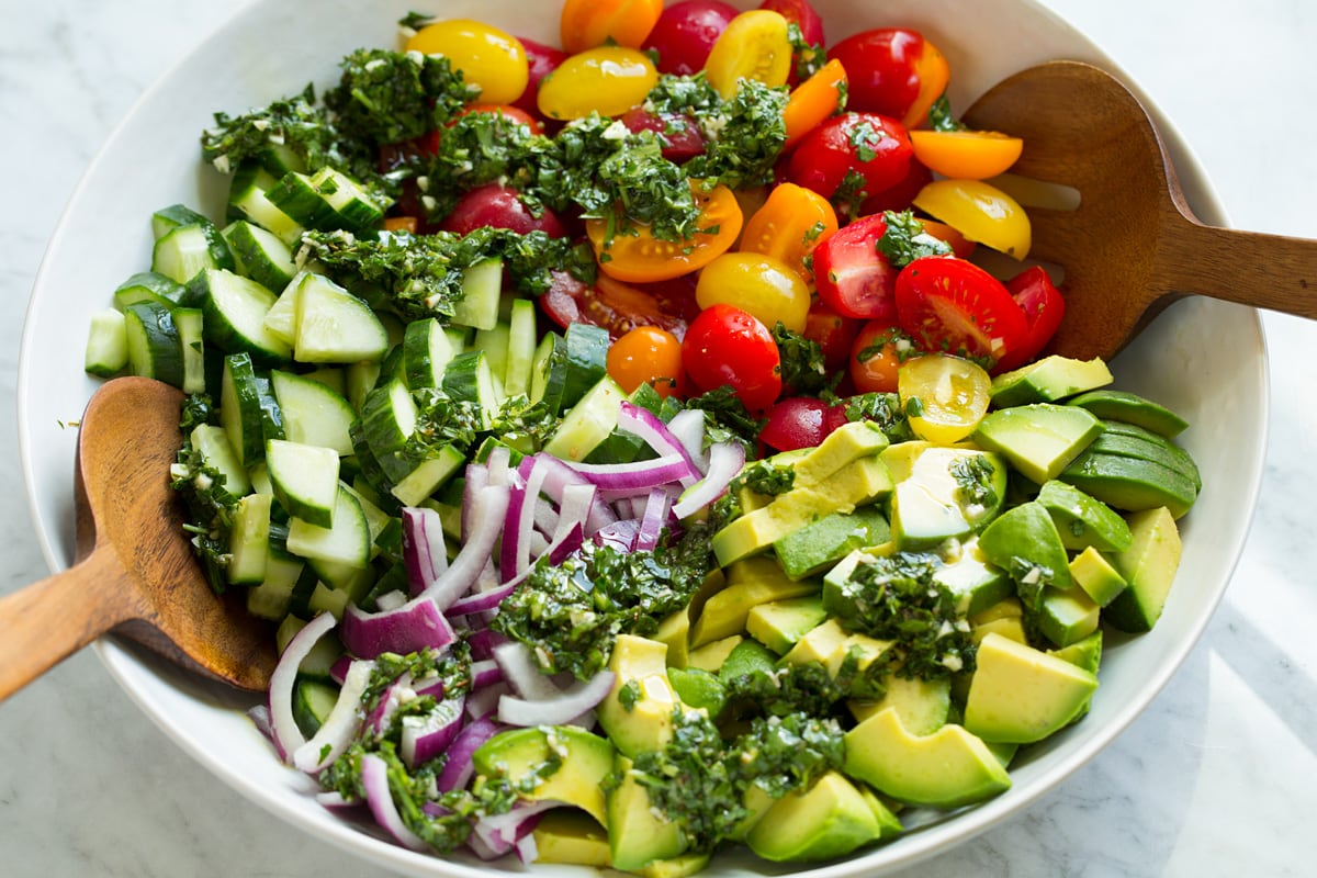 Avocado salad in a mixing bowl shown before tossing with dressing.