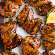 Close up image of huli huli chicken thighs on a platter. Shown overhead.