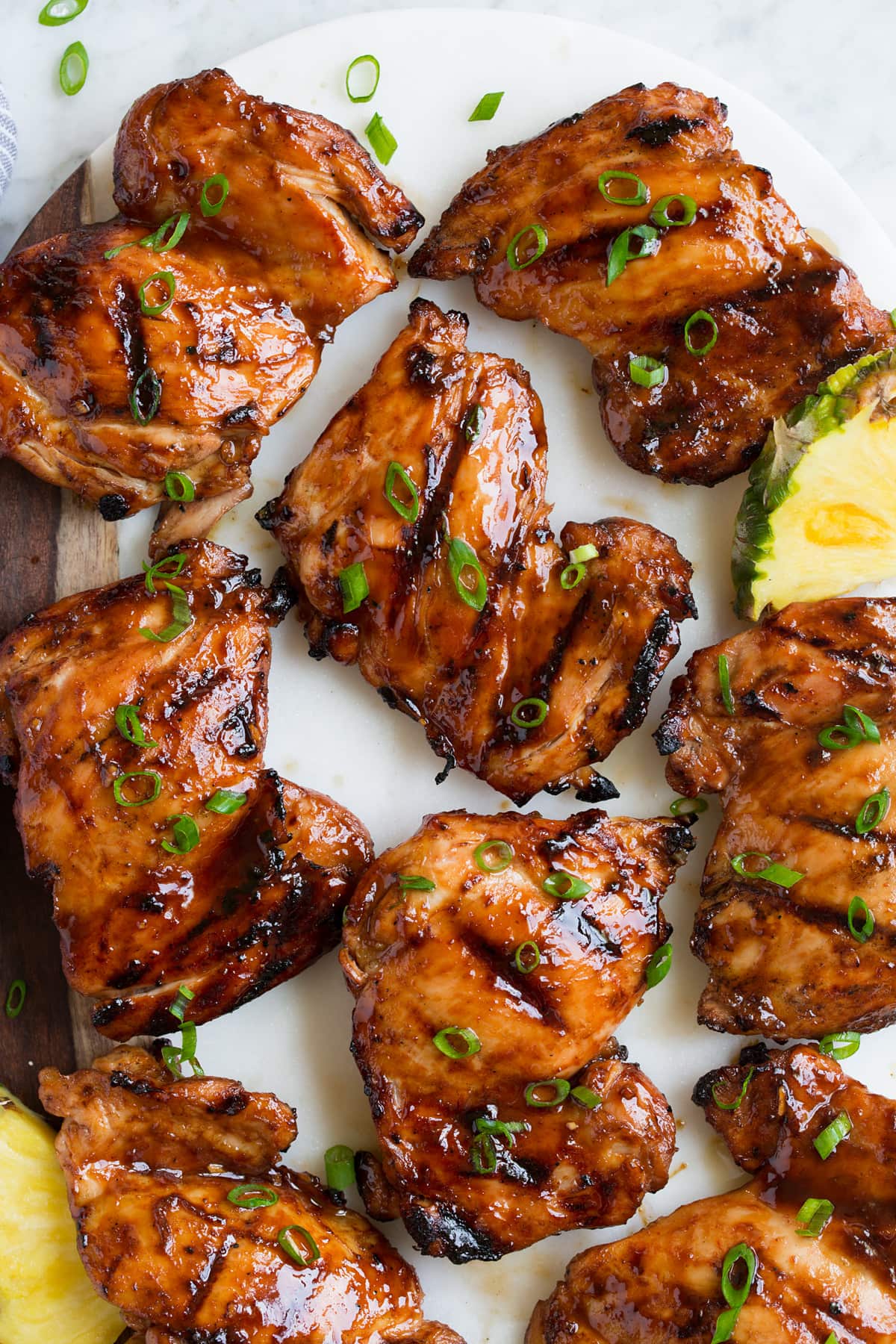 Close up image of huli huli chicken thighs on a platter. Shown overhead.