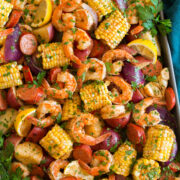 Image shown overhead of shrimp boil after cooking poured out and spread onto a large baking sheet.