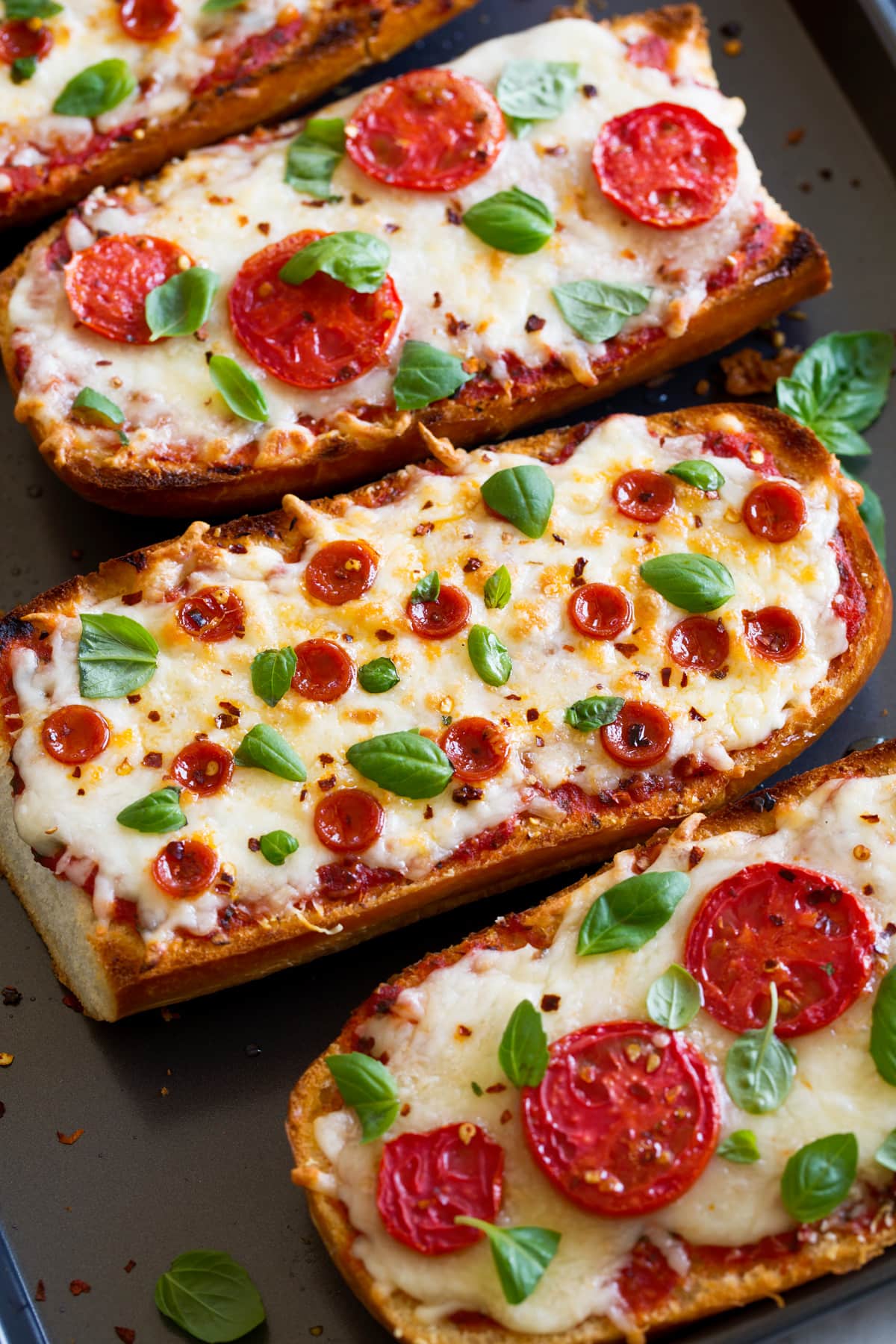 French Bread Pizza shown from a side angle on a baking sheet.