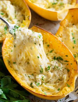 Cheesy spaghetti squash shown with a fork removing a portion.