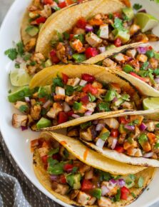 Chicken tacos on a platter shown from a side angle.